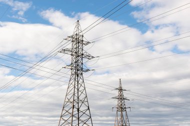 Gökyüzüne karşı güçlü güç telleri ile metal direkleri yüksek voltajlı teknolojik güç hatları