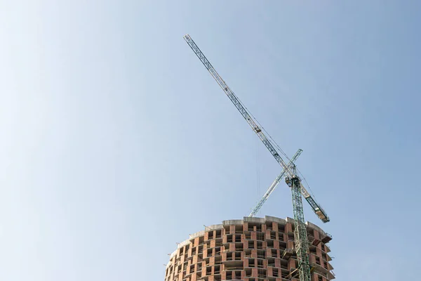 蓝天上的高层建筑起重机根据建筑设计采用现代金属 混凝土和砖砌技术建造多层住宅建筑 — 图库照片