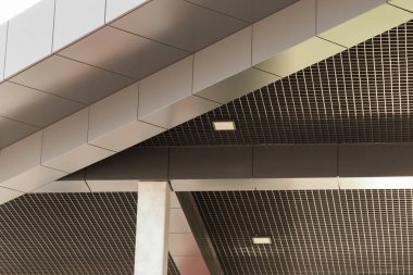 Geometric color elements of the building's facade with planes, lines, corners with highlights and reflections for an abstract background and texture of gray, orange, white colors. Place for text