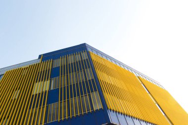 Bina cephesinin geometrik renk unsurları uçaklar, çizgiler, röfleli köşeler ve soyut arka plan ve mavi, sarı, turuncu, gri renklerin dokusu için yansımalar. Metin için yer