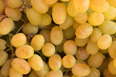 Bir mağaza vitrininde, markette, süpermarkette bir demet sarı beyaz üzüm.