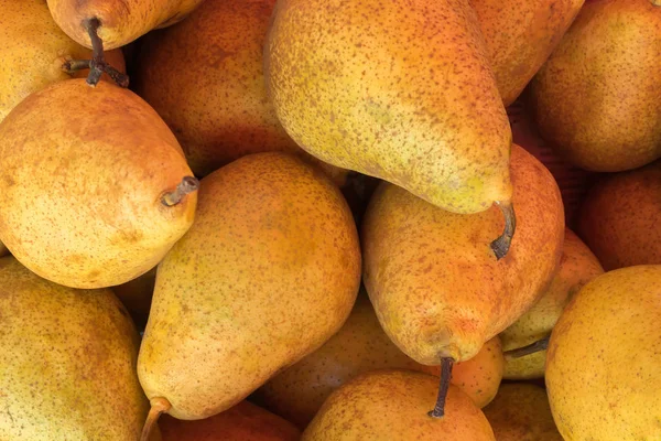 Yellow ripe pears lined up for sale in a supermarket