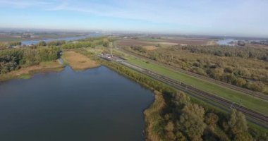 Demiryolunun kentsel olmayan alanının havadan görünümü, doğa peyzaj alanı ve göl, Hollanda