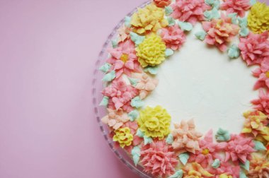 krem renkli çiçekler bir stand ile lezzetli beyaz pasta