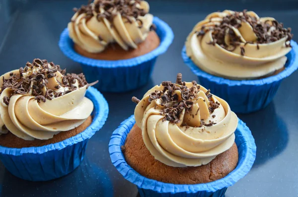 cupcakes in blue molds capsules with different creams