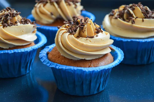 cupcakes in blue molds capsules with different creams