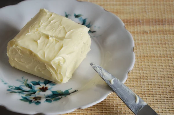 bir tabak üzerinde tereyağı. bir bıçak ve bir peçete yakın. 