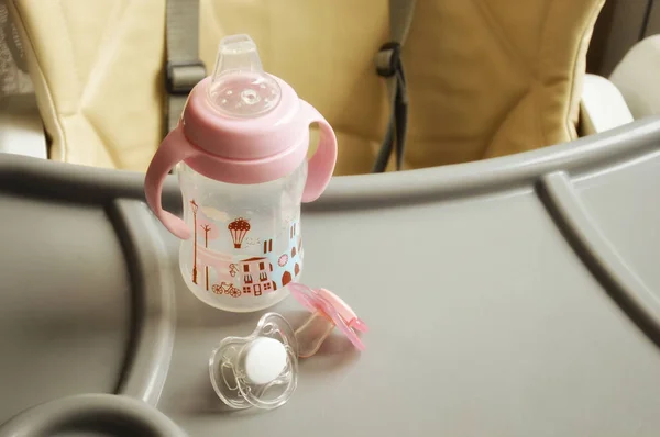 Bebek şişesi ve beslenme masasında iki emzik