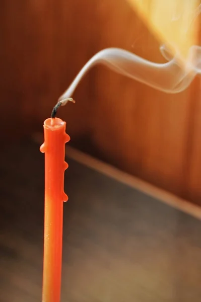 burning candle. red candle with flying smoke.