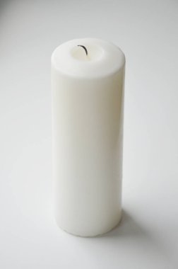 Arka planda beyaz bir mum. Beyaz. Büyük bir mum..