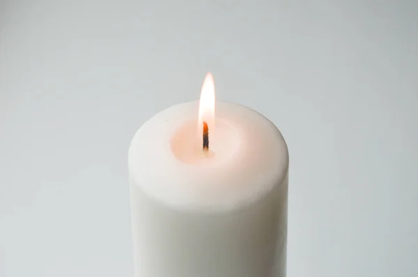 white candle on a light background. white. a large candle.
