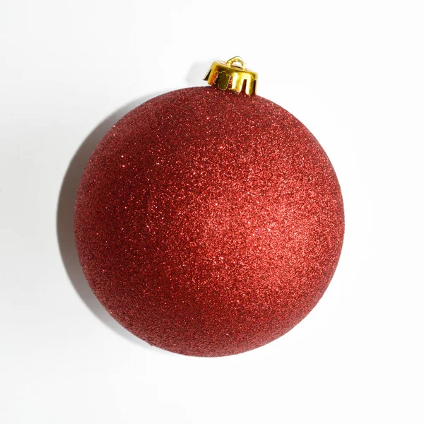 Red shiny ball on Christmas tree. Decorations on the Christmas tree. Christmas. New year. Red ball on white background.