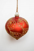 Vánoční stromeček červený míč se zlatými flitry na bílém pozadí. Nový rok, Vánoce.