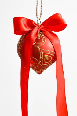 Beyaz arka planda altın pulları olan kırmızı bir Noel ağacı topu. Yeni yıl, Noel.