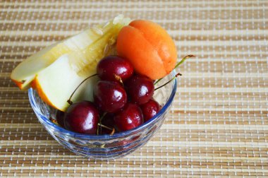 Bir tabak meyve. İyi beslenme. Kayısı, kiraz, cam tabakta kavun. Kahvaltı.