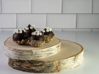 Smores kek topları üzerinde kraker, çikolata kaplama ve küçük şekerlemeler beyaz bir tezgahın üzerinde iki parça gerçek ahşap üzerinde oturuyor..