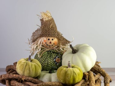 Çuval bezi şapkalı mini korkuluk sonbahar dekorasyonu gibi bir ülke için etrafında küçük yeşil sukabakları olan ahşap bir çelengin üzerinde oturuyor..