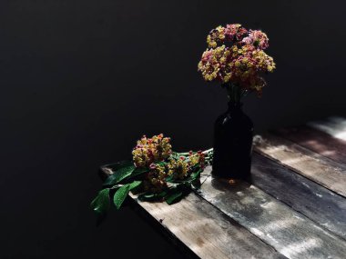 güzel Lantana camara veya bez cam şişe ve ahşap masa ıslak yeşil yapraklar altın çiçek 