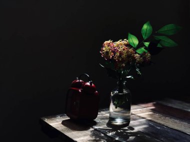 cam şişe ve kırmızı vintage çalar saat rustik ahşap masa üzerinde güzel Lantana camara çiçekler 