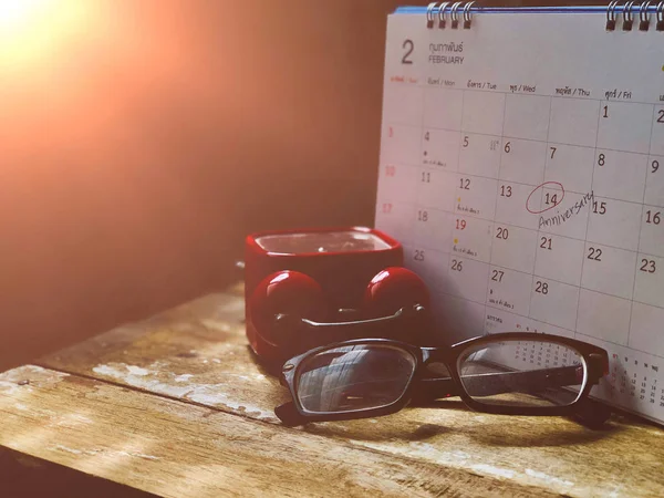 在木桌上有闹钟和眼镜的日历 — 图库照片