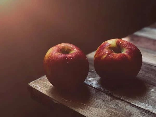 two ripe nectarines on wooden table edge