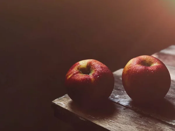 two ripe nectarines on wooden table edge