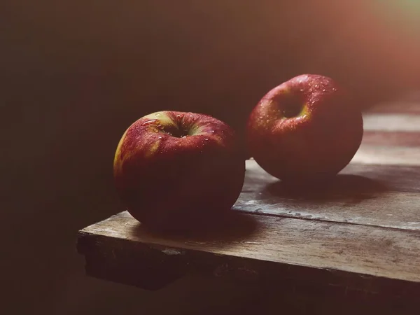 two ripe nectarines on wooden table edge