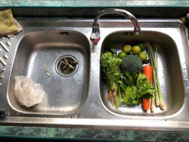 Taze sebzeler iştah açıcı, Kaffir kireç yaprakları, kişniş, limon, brokoli, limonçim, ve havuç, kırsal mutfakta lavabo su, sabah ışığı ile, hazırlık sağlıklı gıda. Üst görünüm.