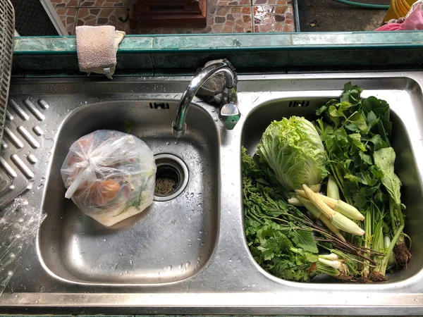 fresh vegetables in kitchen sink