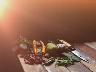 Hazırlama ve pişirme sebze, fesleğen yaprakları, kaffir kireç yaprakları, limon ve masada bıçak 