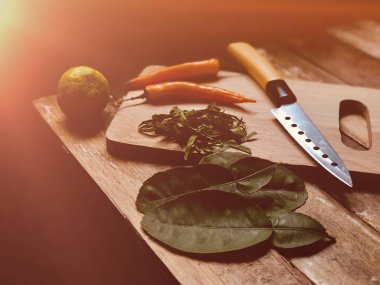 biber, Fesleğen yaprakları, Bıçak ile ahşap tahta üzerinde Kaffir kireç yaprakları 