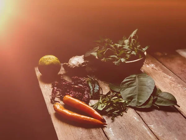 stock image Preparation and cooking vegetables, basil leaves, kaffir lime leaves, lime and knife on table 