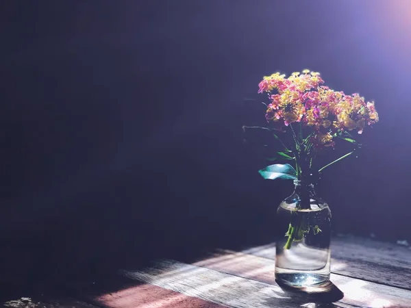Ahşap Masa Üzerinde Cam Şişe Lantana Camara Çiçekler — Stok fotoğraf