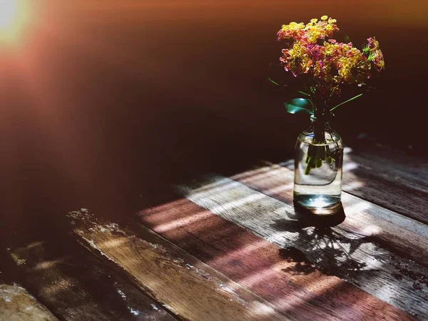 Ahşap Masa Üzerinde Cam Şişe Lantana Camara Çiçekler — Stok fotoğraf