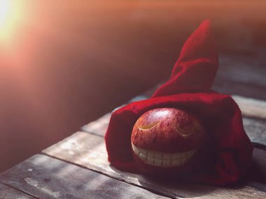 Ahşap masa yüzeyine oyulmuş gülen yüz ile Kırmızı Elma, kopya alanı 