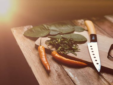 kesilmiş kaffir kireç yaprakları ve ahşap masada bıçak ile biber ile kesme tahtası, Tay baharatlı gıda için Malzemeler