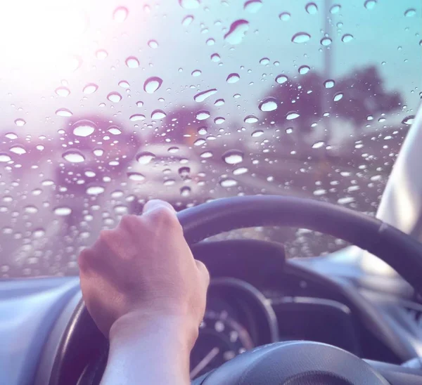 erkek el ve şehir trafiğinde yağmur damlaları ile pencereden görünümü 