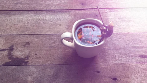 Relaxation in coffee time.Black coffee in white mug,Miniature of fisherman sitting and fishing, relaxed on the cup edge, in Americano coffee,free space for your text, with lens flare, selective focus.