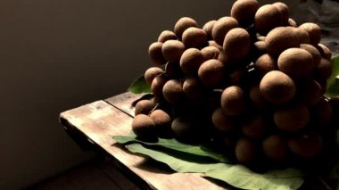 Metin tasarımınız için yeri olan boş eski tahta üzerinde taze Longan. Kırsal yaşam ve karanlık arka plan, loş ışık. Seçici odak