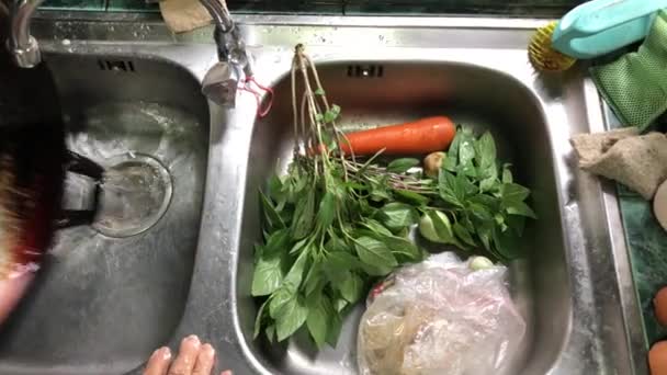 アジアの女性の高齢者の手は 素朴なキッチンでシンク水で 朝食や洗浄皿のための食品を準備 朝の光 新鮮な野菜を食欲をそそる 健康食品 トップビュー — ストック動画