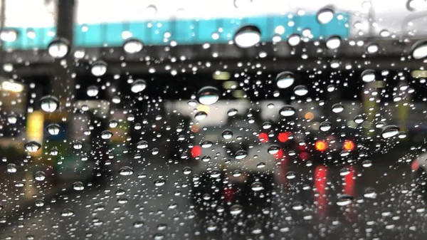 夜の雨の日に街路灯とカラフルなボケ ぼやけた景色 多くの雨の中で道路上の車を運転 — ストック写真