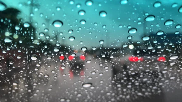 Colorful bokeh with street light at night rainy day,blurred view,drive car on the road in the lot rain.