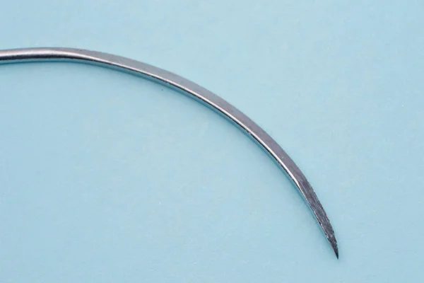 Chirurgiczna igła urazowa na niebieskiej powierzchni — Zdjęcie stockowe