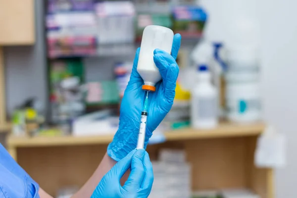Las mujeres veterinarias con guantes azules extraen una droga blanca ingenio — Foto de Stock