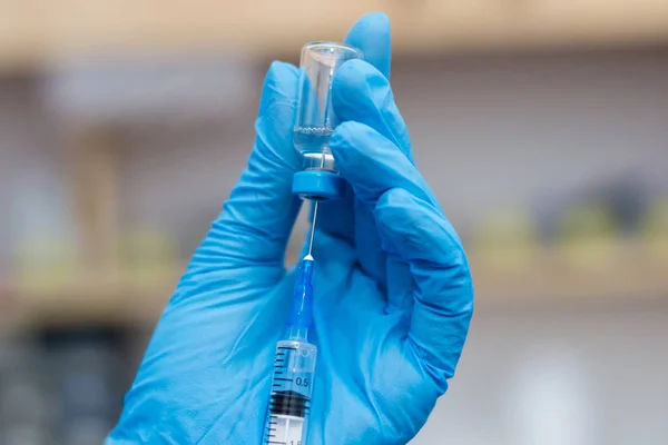 Las mujeres veterinarias con guantes azules que preparan una vacuna — Foto de Stock