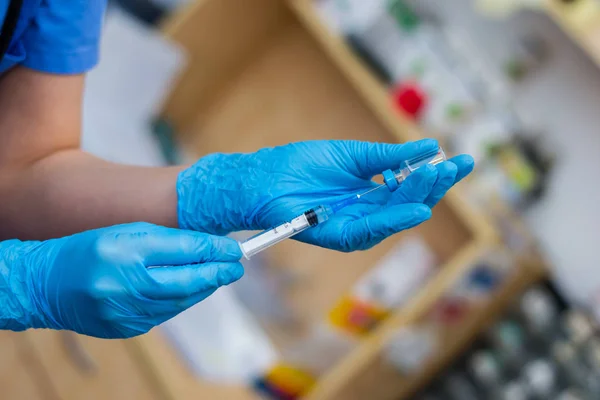 Ветеринарні жінки з блакитними рукавичками готують вакцину — стокове фото