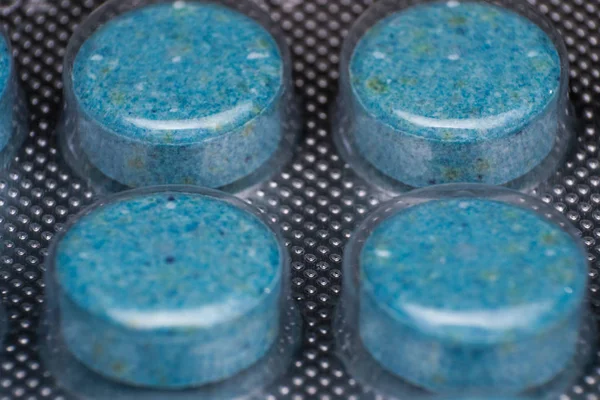 blue pills packed in plastic wrap close-up