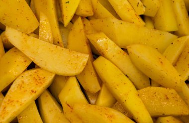 Taze kesilmiş patates dilimlenmiş ve terbiyeli 