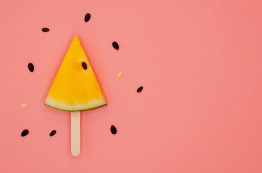 Sarı karpuz dondurma ahşap sopa ile yaz saati metin için yer ile pembe arka plan üzerinde izole için tohumlar üzerinde dilim.