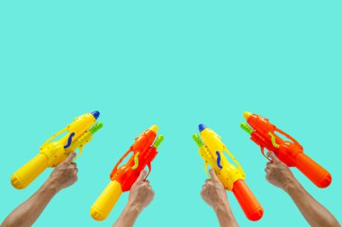 Hands holding colorful water gun for Water or Songkran festival. clipart